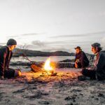 three men in front of bonfire