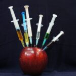 apple fruit with plastic syringes
